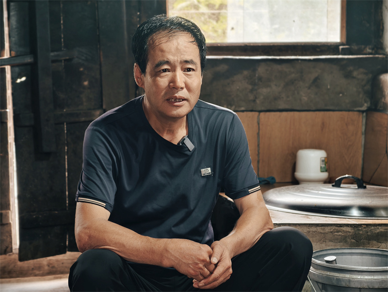 图片2、坐在老屋的锅台旁，李井印讲述他的父亲母亲照顾八路军伤员的故事。郭明明摄.jpg