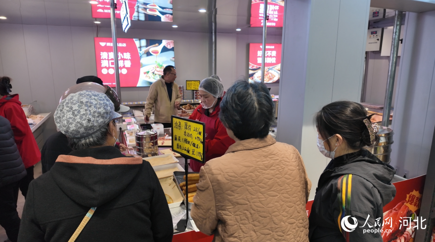 同福爆品店（每乐鲜店）周边居民排队购买现做油条、酸奶麻花。人民网记者朱延生摄